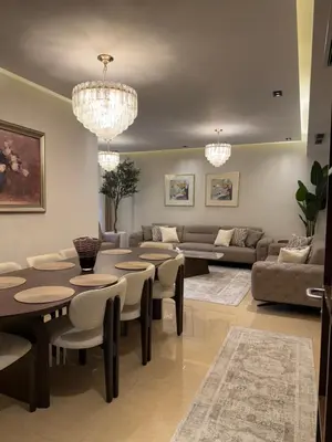 a living room with chandeliers and a table and chairs at مطر in Amman