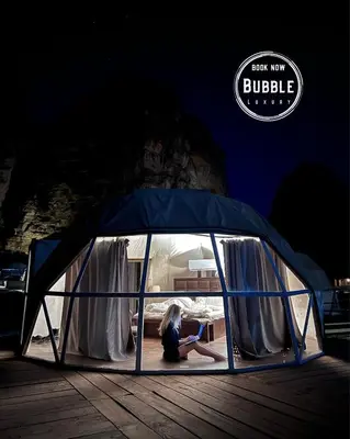 a woman sitting in a tent in the dark at WADi RUM BUBBLE in Wadi Rum