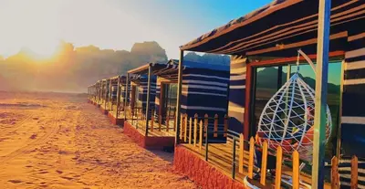 a row of houses on the beach with a surfboard at Nile bedouin camp in Aqaba