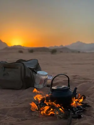 a camp fire with a tea pot and a bag at Nile bedouin camp in Aqaba