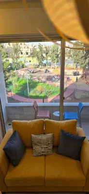 a couch with pillows sitting in a room with a window at Rainbow 7 in Amman