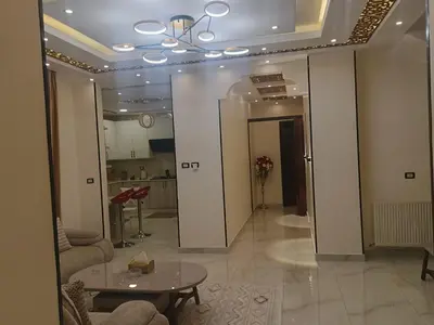 a living room with a table and a kitchen at شقق في عمان in Al Jafr