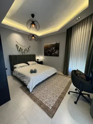 a bedroom with a large bed and a chair at The FWD Living - FWD2 in Amman
