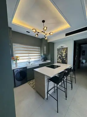 a kitchen with a sink and a counter with chairs at The FWD Living - FWD2 in Amman