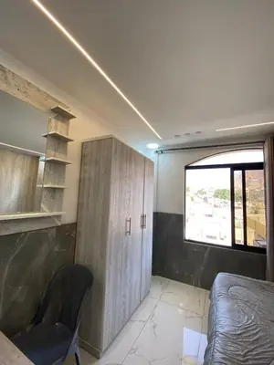 a bedroom with a bed and a cabinet and a window at Avatar Hotel-Aqaba in Aqaba