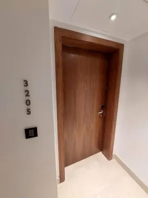 a wooden door in a room with a tile floor at Skyline Residence Apartment Stunning City Views in Amman