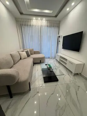 a living room with a couch and a flat screen tv at Boulevard Comfort Haven, apt with stunning veiw in Amman