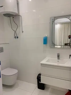 a bathroom with a sink and a toilet and a mirror at Boulevard Comfort Haven, apt with stunning veiw in Amman