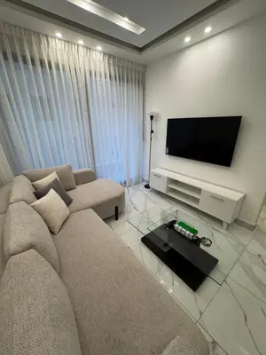 a living room with a couch and a flat screen tv at Boulevard Comfort Haven, apt with stunning veiw in Amman