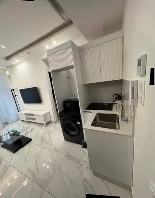 a white kitchen with a sink and a stove at Boulevard Comfort Haven, apt with stunning veiw in Amman