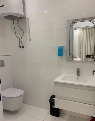 a bathroom with a toilet and a sink and a mirror at Boulevard Comfort Haven, apt with stunning veiw in Amman
