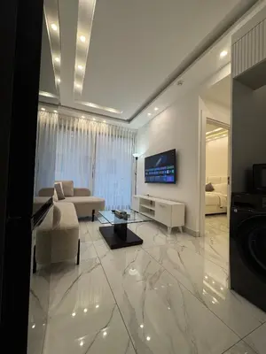 a living room with a couch and a tv at Boulevard Comfort Haven, apt with stunning veiw in Amman