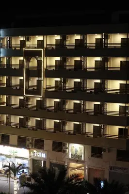 a large apartment building with balconies at night at Mariam Economy Hotel in Aqaba