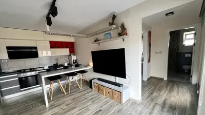 a kitchen with a large flat screen tv on the wall at An Overlooking Rooftop in Amman in Amman