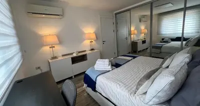 a bedroom with a bed and a desk with two beds at An Overlooking Rooftop in Amman in Amman