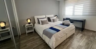 a bedroom with a bed and two lamps and a window at An Overlooking Rooftop in Amman in Amman