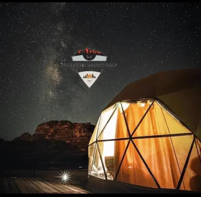 a tent under a night sky with the milky way at RUM LOREN lUXURY CAMP in Wadi Rum