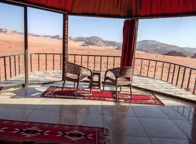 two chairs on a porch with a view of the desert at Starlit Wadi Rum camp in Wadi Rum