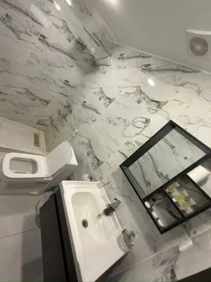 a white bathroom with a sink and a toilet at Dune Horizon Camp in Wadi Rum