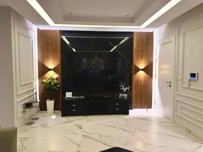 a living room with a large television and a marble floor at Elegant & Cozy Apartment in Heart of Amman in Amman