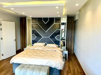 a bedroom with a large bed with a wall at Elegant & Cozy Apartment in Heart of Amman in Amman
