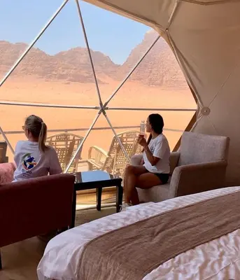 two women sitting in a tent looking out at the desert at Luxury Mars Camp in Wadi Rum