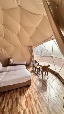 two beds in a room with a tent at Luxury Mars Camp in Wadi Rum