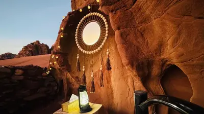 a mirror on a rock wall in a bathroom at Magic Cave Night Tours in Wadi Rum