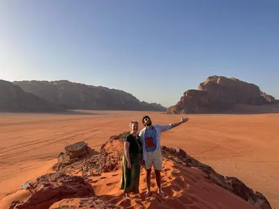 two men standing on a rock in the desert at Magic Cave Night Tours in Wadi Rum