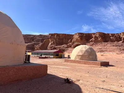 two domes in the desert with a mountain in the background at Wadi Rum Desert Wonders Camp in Disah