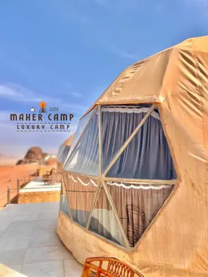a large dome tent with chairs in the desert at Wadi rum maher luxury camp in Wadi Rum