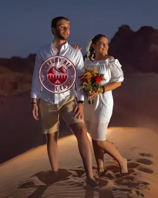 a man and woman standing on the beach with a frisbee at RUM lUXURY MM SANDS CAMP in Wadi Rum