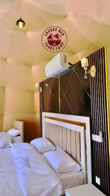 a bedroom with two beds and a sign on the wall at RUM lUXURY MM SANDS CAMP in Wadi Rum