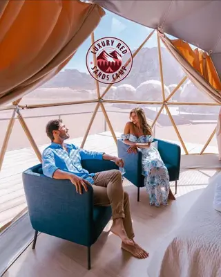 a man and woman sitting in chairs in a tent at RUM lUXURY MM SANDS CAMP in Wadi Rum