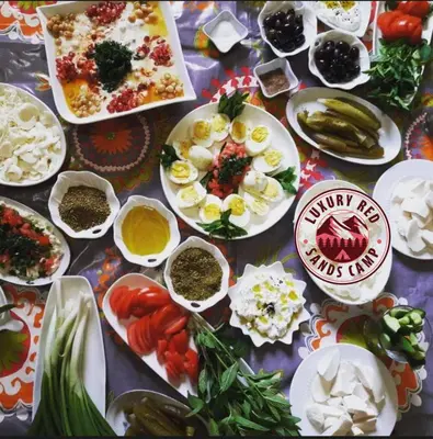 a table topped with plates of food and other foods at RUM lUXURY MM SANDS CAMP in Wadi Rum