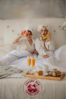 two people laying in bed with food and drinks at RUM lUXURY MM SANDS CAMP in Wadi Rum
