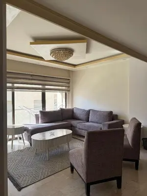 a living room with a couch and a table at Deir Ghbar apartment 116 in Amman