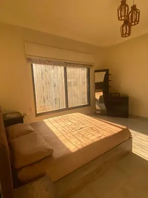 a bedroom with a large bed and a piano at studio apartment for rent in Amman