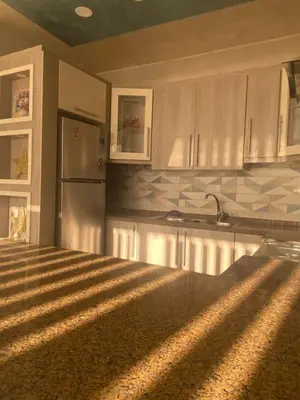 a kitchen with white cabinets and a stainless steel refrigerator at studio apartment for rent in Amman
