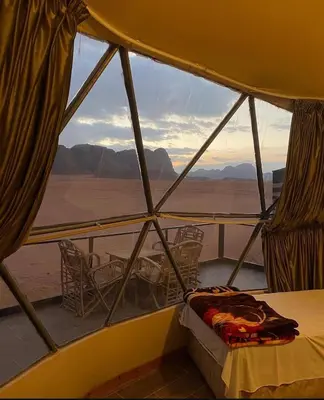 a room with a bed and a view of the desert at Golden Camp in Wadi Rum