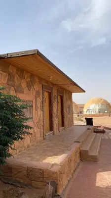 a small stone building with steps and a glass dome at Golden Camp in Wadi Rum