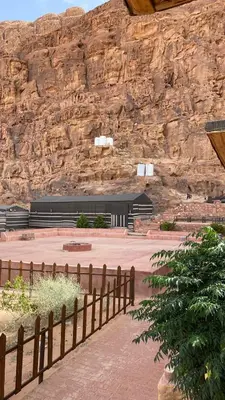 a building in front of a rock wall at Golden Camp in Wadi Rum