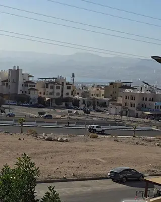 a city with buildings and cars on a road at عبدالرحمن الشطناوي in Aqaba
