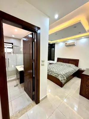 a bedroom with a bed and a walk in shower at Bright & Comfortable Villa in Abu Nuseir in Al Jafr