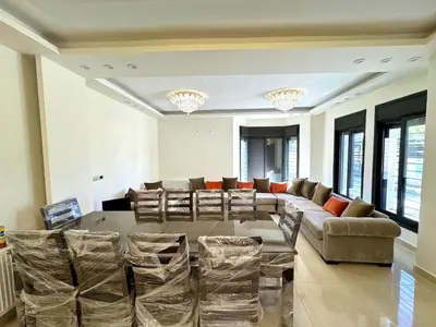 a large living room with a large table and chairs at Bright & Comfortable Villa in Abu Nuseir in Al Jafr