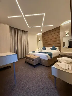 a hotel room with two beds and a desk at شقق سلين الفندقية in Amman