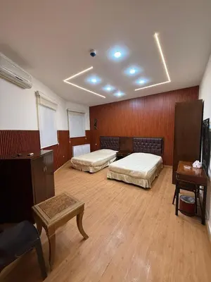 a large room with two beds and a table at شقق سلين الفندقية in Amman