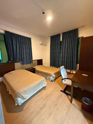 a hotel room with two beds and a desk at شقق سلين الفندقية in Amman