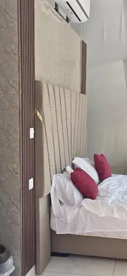 a bed with red and white pillows in a room at RUM FIRAS lUXURY CAMP in Wadi Rum