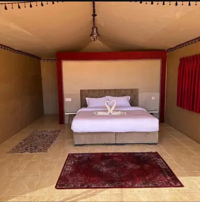 a bedroom with a large bed with a bow on it at Nebula Rum Camp in Wadi Rum